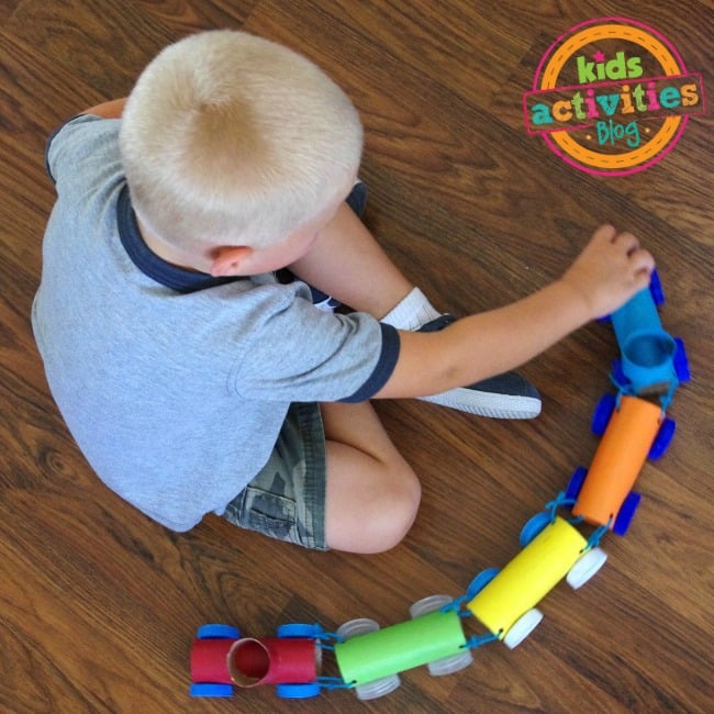 Toilet Paper Roll Train Craft completed and boy playing with the finished train craft